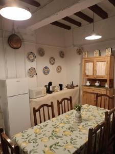 uma cozinha com uma mesa e uma cozinha com pratos na parede em Casa rural de la Abuela em Cadreita