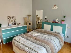 a bedroom with a bed with a blue head board at La Tana: accogliente, romantica, relax in Brescia