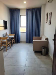 a living room with blue curtains and a couch and a table at Residence 110 (Hotel and Apartments) in Phnom Penh