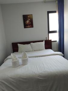 een groot wit bed met 2 witte kussens erop bij Residence 110 (Hotel and Apartments) in Phnom Penh