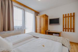 a bedroom with a bed and a tv and a window at Weingut und Gästehaus Salzl in Illmitz