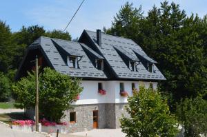a house with a black roof at Guest House Plitvice Villa Verde in Plitvička Jezera