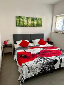 um quarto com uma cama preta e branca com almofadas vermelhas em Mohnblume em Großrinderfeld