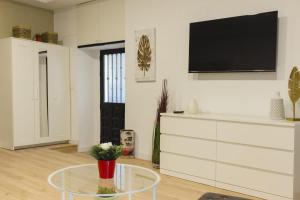 sala de estar con mesa y TV en la pared en Alojamiento central, en Madrid