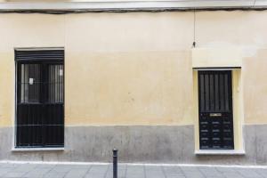un edificio con dos puertas negras y una acera en Alojamiento central, en Madrid