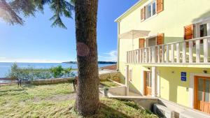 a house with a tree next to the ocean at Villa Bonazza in Novigrad Istria