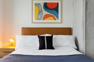 1 dormitorio con 1 cama y una pintura en la pared en Stubbs by AvantStay Brand New Condo in Austin w Amazing Amenities, en Austin