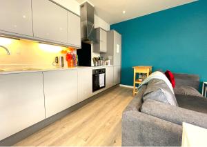 a living room with a couch and a kitchen at City Views from modern apartment in Bristol