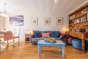 a living room with a couch and a table with a bowl of fruit at Sea Haven in Wells next the Sea