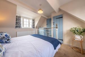 a bedroom with a white bed and a blue door at Sea Haven in Wells next the Sea