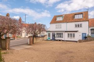 a white house on the side of a street at Sea Haven in Wells next the Sea