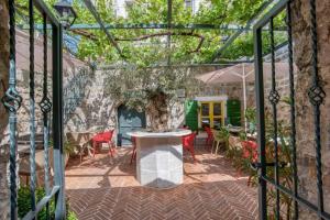 a patio with a table and chairs and a tree at Royal Garden Apartments & Gastronomy in Budva