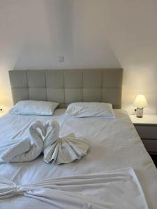 een wit bed met twee handdoeken in hartvorm bij Utopia Kavos in Kavos
