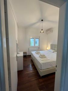 een witte slaapkamer met een bed en een raam bij Utopia Kavos in Kavos
