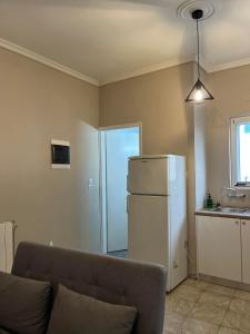 een woonkamer met een bank en een koelkast bij Utopia Kavos in Kavos