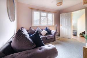 a living room with a leather couch and a window at Banchory House - SJA Stays - 2 Bed Apartment in Banchory