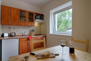 a kitchen with a wooden table with a glass of wine at Apartment Marketa in Pec pod Sněžkou