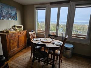 - une salle à manger avec une table, des chaises et des fenêtres dans l'établissement NIGHT & DAY, à Honfleur