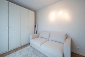 un divano bianco in una stanza con parete bianca di Beautiful beach-appartment between Knokke & Bruges a Zeebrugge