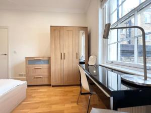 1 dormitorio con escritorio, 1 cama y ventana en Split Level 3 Bed- Hyde Park, en Londres