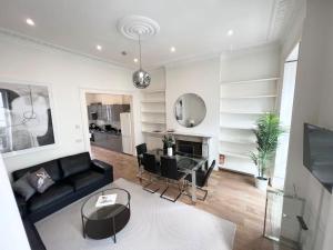 sala de estar con sofá negro y mesa en Split Level 3 Bed- Hyde Park, en Londres