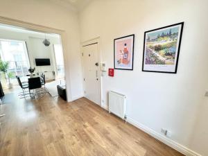sala de estar con paredes blancas y suelo de madera dura en Split Level 3 Bed- Hyde Park, en Londres