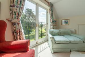 uma sala de estar com um sofá e uma janela em Saxon Shore Cottage em Burnham Deepdale