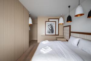 ワルシャワにあるWola Homely & Chic Apartmentのベッドルーム1室(大きな白いベッド1台、タオル2枚付)