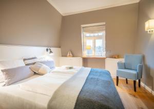 a bedroom with a large bed and a blue chair at Logierhaus K15 Appartement 12 in Borkum
