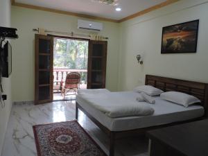 a bedroom with a bed and a door to a patio at Abba's Glory Land - Agonda in Agonda