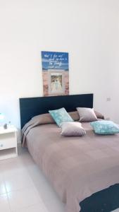 Un dormitorio con una cama grande con almohadas. en Appartamenti Cala del Sole - INFINITYHOLIDAYS en Costa Paradiso