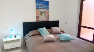 1 dormitorio con 1 cama con 2 almohadas en Appartamenti Cala del Sole - INFINITYHOLIDAYS en Costa Paradiso