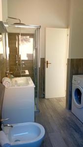 y baño con lavabo y lavadora. en Appartamenti Cala del Sole - INFINITYHOLIDAYS en Costa Paradiso