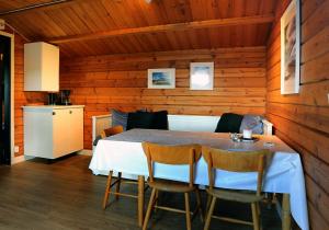 a dining room with a white table and chairs at Urshult Camping in Urshult