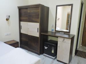 een slaapkamer met een houten kast en een spiegel bij Divine Kingdom at Abba's Agonda in Agonda