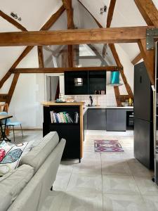 a living room with a couch and a kitchen at Duplex à la campagne in Vermenton