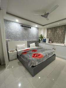 una camera da letto con un grande letto con fiori rossi di Hotel The Heera Divine a Kānpur