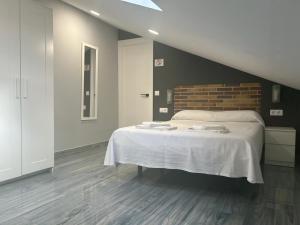ein Schlafzimmer mit einem großen Bett mit weißer Bettwäsche in der Unterkunft casa julian-inn in Madrid