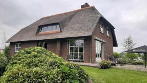 a brown brick house with a gambrel roof at B&B Pension "Op'e Koai" in Jirnsum