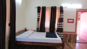 a bed in a room with curtains and a bed sidx sidx sidx sidx at Mahabala Valley Guest House in Gokarna