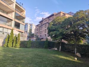 un patio verde con un árbol y un edificio en Luxurious Intimacy Hideaway - Self Check in, en Ereván