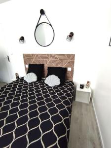 a bedroom with a black and white bed and a lamp at résidence hyper centre parking indigo inclus à 50m in Dieppe