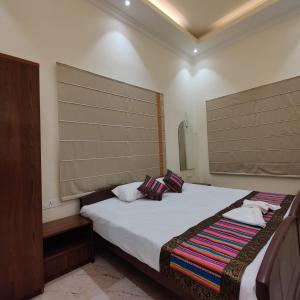 a bedroom with a bed with two pillows on it at HERITAGE HAVELI VARANASI in Varanasi