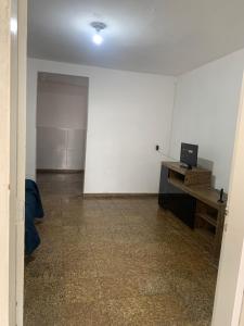 ein leeres Zimmer mit einem Schreibtisch und einer weißen Wand in der Unterkunft Casa na praia do centro in Marataizes