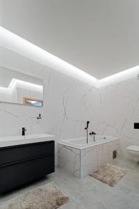 ein weißes Bad mit einer Badewanne und einem WC in der Unterkunft Villa Holiday Hevlín in Hevlín