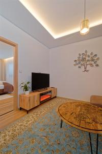 uma sala de estar com uma televisão e uma mesa de centro em Villa Holiday Hevlín em Hevlín