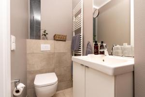 een witte badkamer met een wastafel en een toilet bij Logierhaus K15 Appartement 7 in Borkum