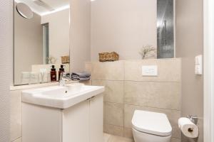 a white bathroom with a sink and a toilet at Logierhaus K15 Appartement 6 in Borkum