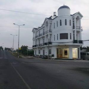 VIEW HOTEL-TRÀM CHIM في Tràm Chim: مبنى ابيض كبير على جانب شارع