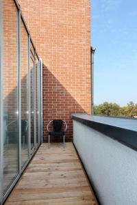 einen Balkon mit einem Stuhl auf einem Backsteingebäude in der Unterkunft H24 Hoteltow in Teltow